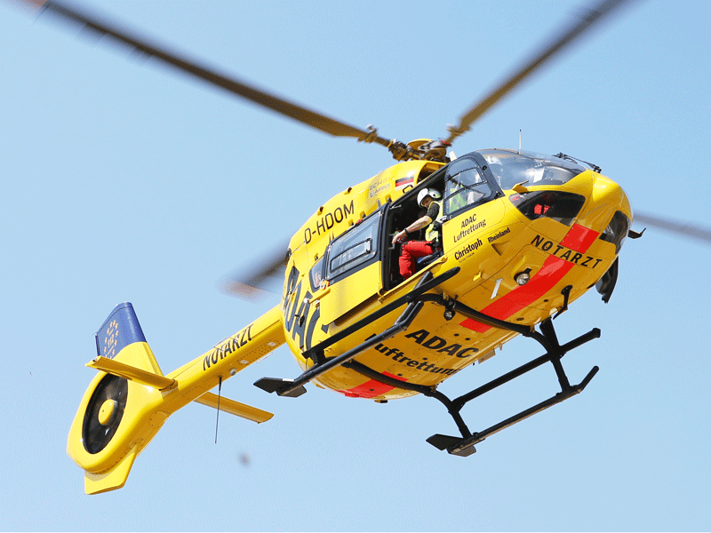 Ein gelber Rettungshubschrauber der ADAC Luftrettung im Flug, mit der Aufschrift "NOTARZT".