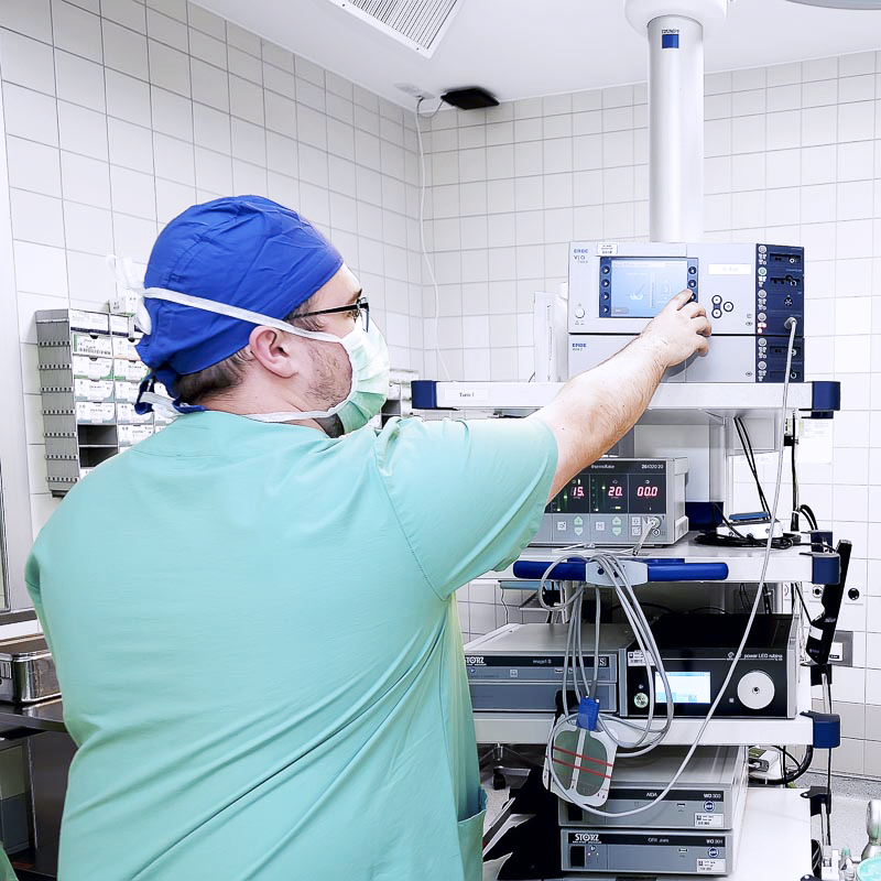 Im Bild ist ein Arzt zu sehen, der medizinische Geräte im OP bedient.