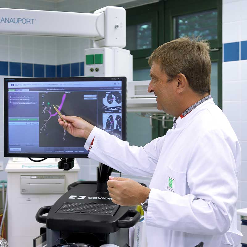 Ein Arzt zeigt auf einen Bildschirm mit medizinischen Bildern in einem Krankenhaus.