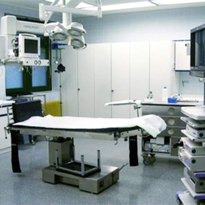 Ein Operationssaal mit einem Operationstisch, chirurgischen Geräten und medizinischen Monitoren.