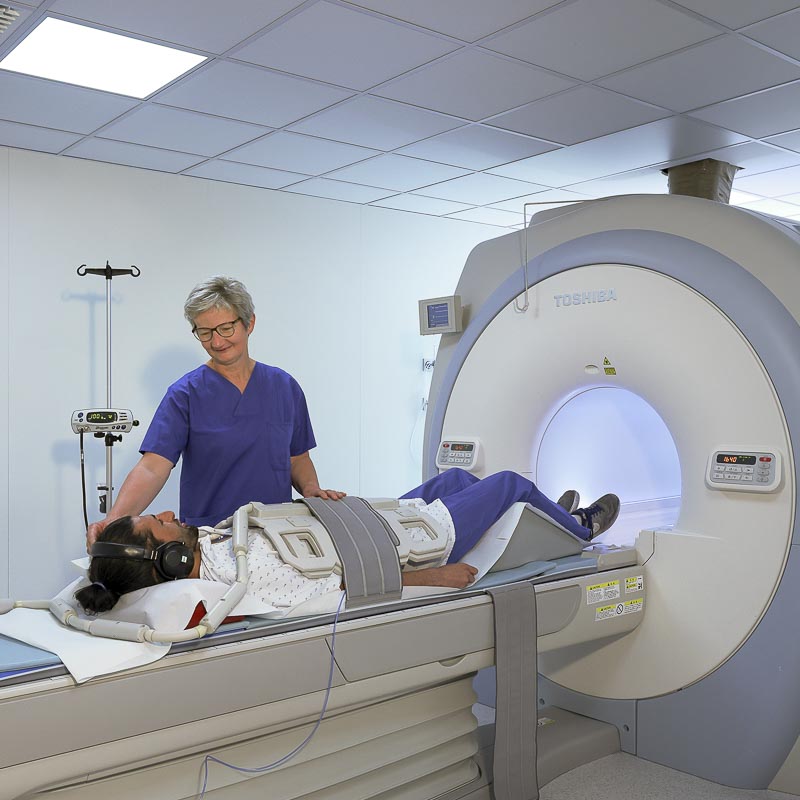 Eine Person erhält eine MRT-Untersuchung, betreut von medizinischem Personal.