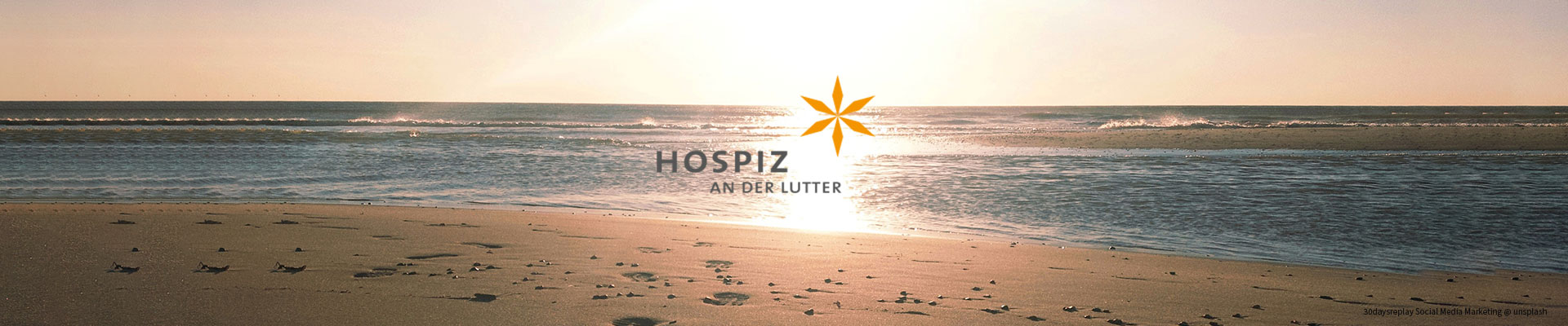 Ein Sonnenuntergang am Meer mit einem Logo: "Hospiz an der Lutter".