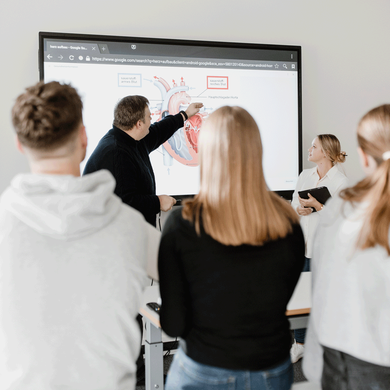 Eine Gruppe von Leuten schaut auf ein Diagramm des Herzens auf einem Bildschirm.